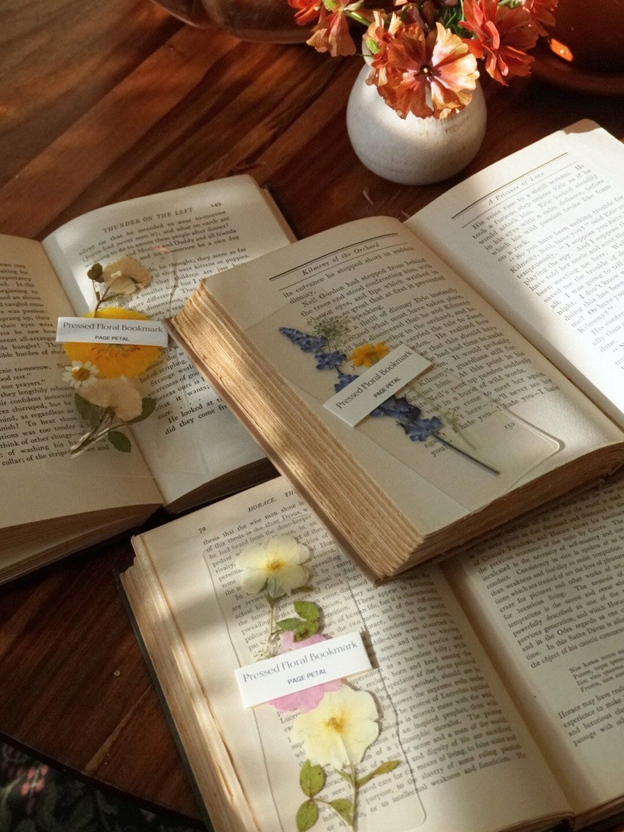 Open vintage books with pressed flower bookmarks